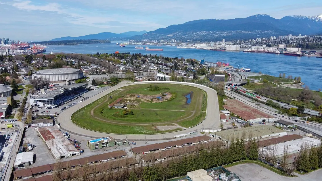 Hastings Racecourse et sa tribune vus du ciel, avec l'inlet Burrard et les montagnes de la North Shore en arrière-plan