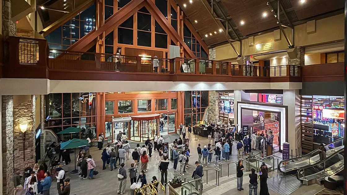 L'atrium à charpente de bois du River Rock Casino Resort, animé de visiteurs, avec l'entrée de la salle de jeu à droite